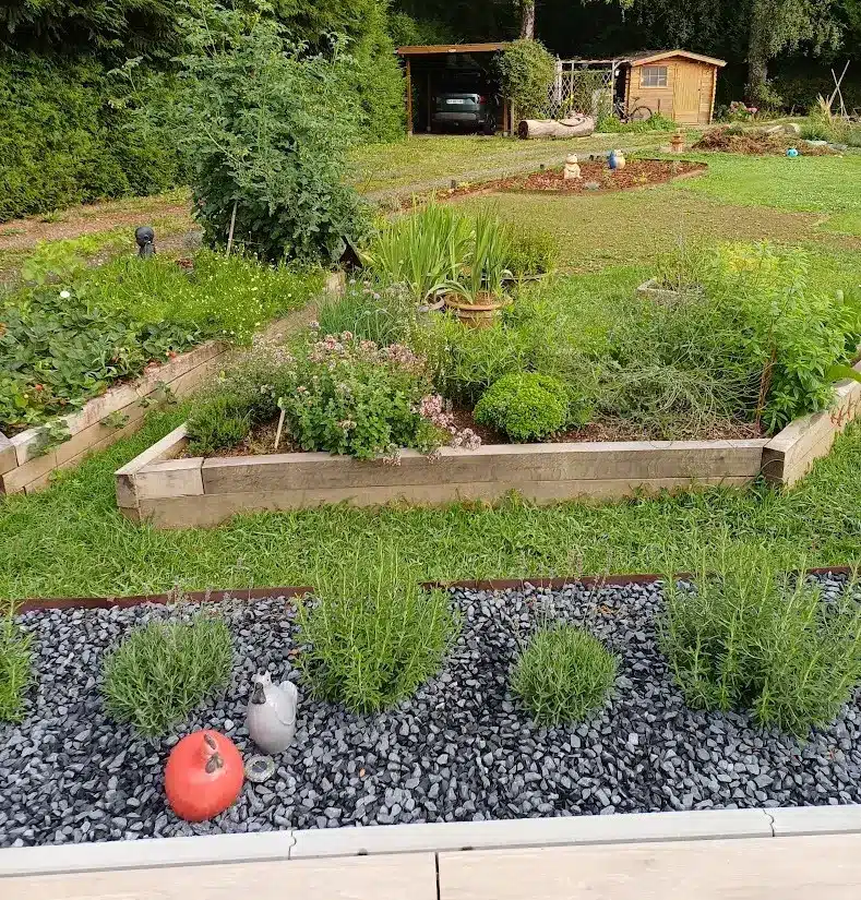 Aménagement d'un potager pratique avec des bacs d'aromatiques à proximité immédiate de la maison pour simplifier la cueillette.